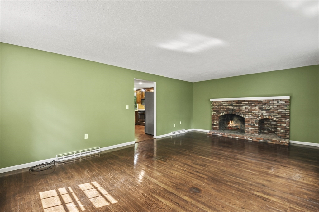 573 Main Street Dunstable, MA 01827 - Photo 12 of 42 a view of empty room with fireplace and wooden floor