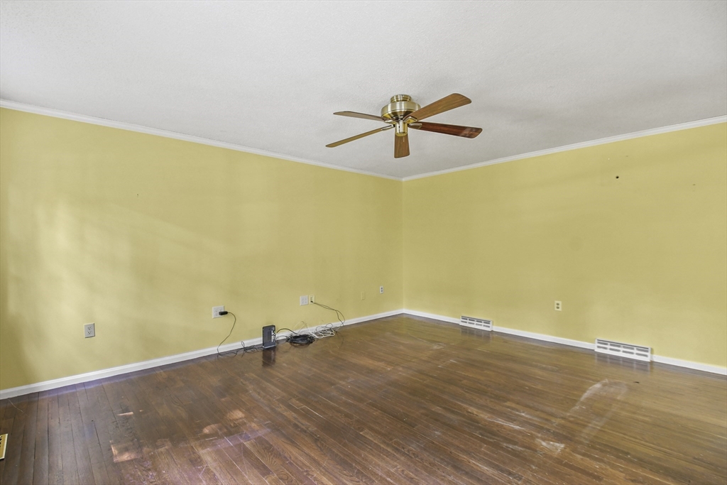 573 Main Street Dunstable, MA 01827 - Photo 3 of 42 a view of a big room with wooden floor and a ceiling fan