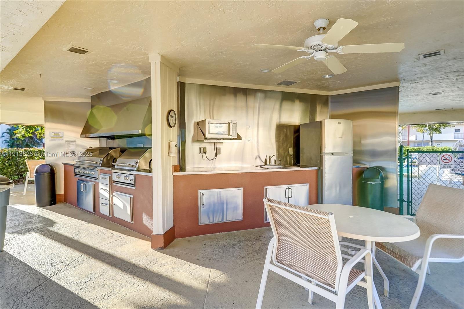 8900 Washington Street, Unit 410 Pembroke Pines, FL 33025 - Photo 32 of 79 a kitchen with stainless steel appliances kitchen island granite countertop a table chairs and a refrigerator
