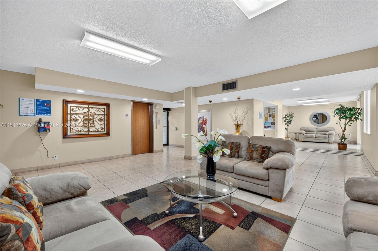 8900 Washington Street, Unit 410 Pembroke Pines, FL 33025 - Photo 77 of 79 a living room with furniture a rug and a table