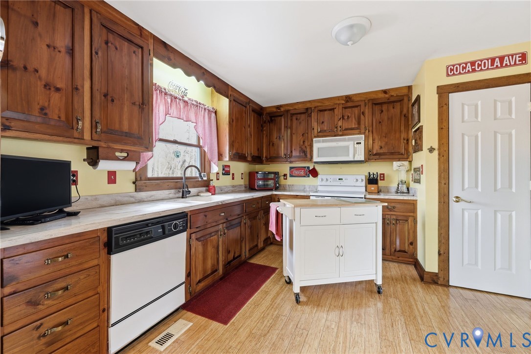4022 Evelake Road Richmond, VA 23237 - Photo 19 of 35 a kitchen with granite countertop wooden floors and white appliances