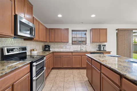 a kitchen with stainless steel appliances granite countertop a sink and stove top oven