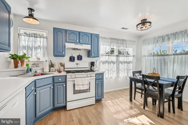 a kitchen with a table chairs stove and cabinets
