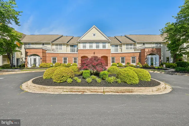 a view of a white house with a yard and plants