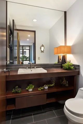 a bathroom with a double vanity sink mirror and toilet