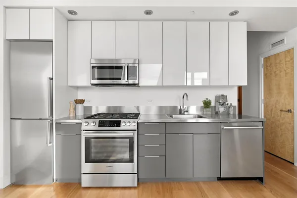 a kitchen with granite countertop white cabinets and stainless steel appliances