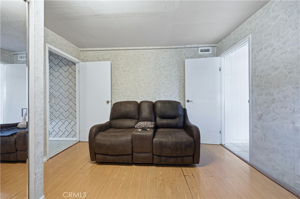 117 Spanner Street Monrovia, CA 91016 - Photo 14 of 33 a living room with furniture and a walk in closet with wooden floor