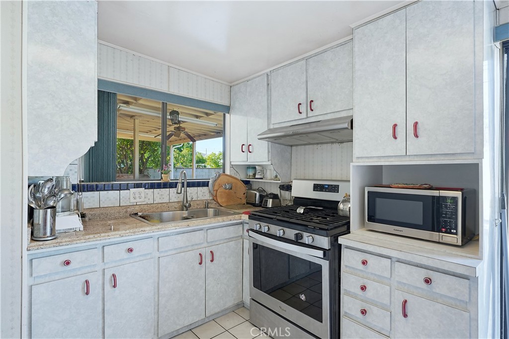 117 Spanner Street Monrovia, CA 91016 - Photo 6 of 33 a kitchen with stainless steel appliances white cabinets and a stove top oven