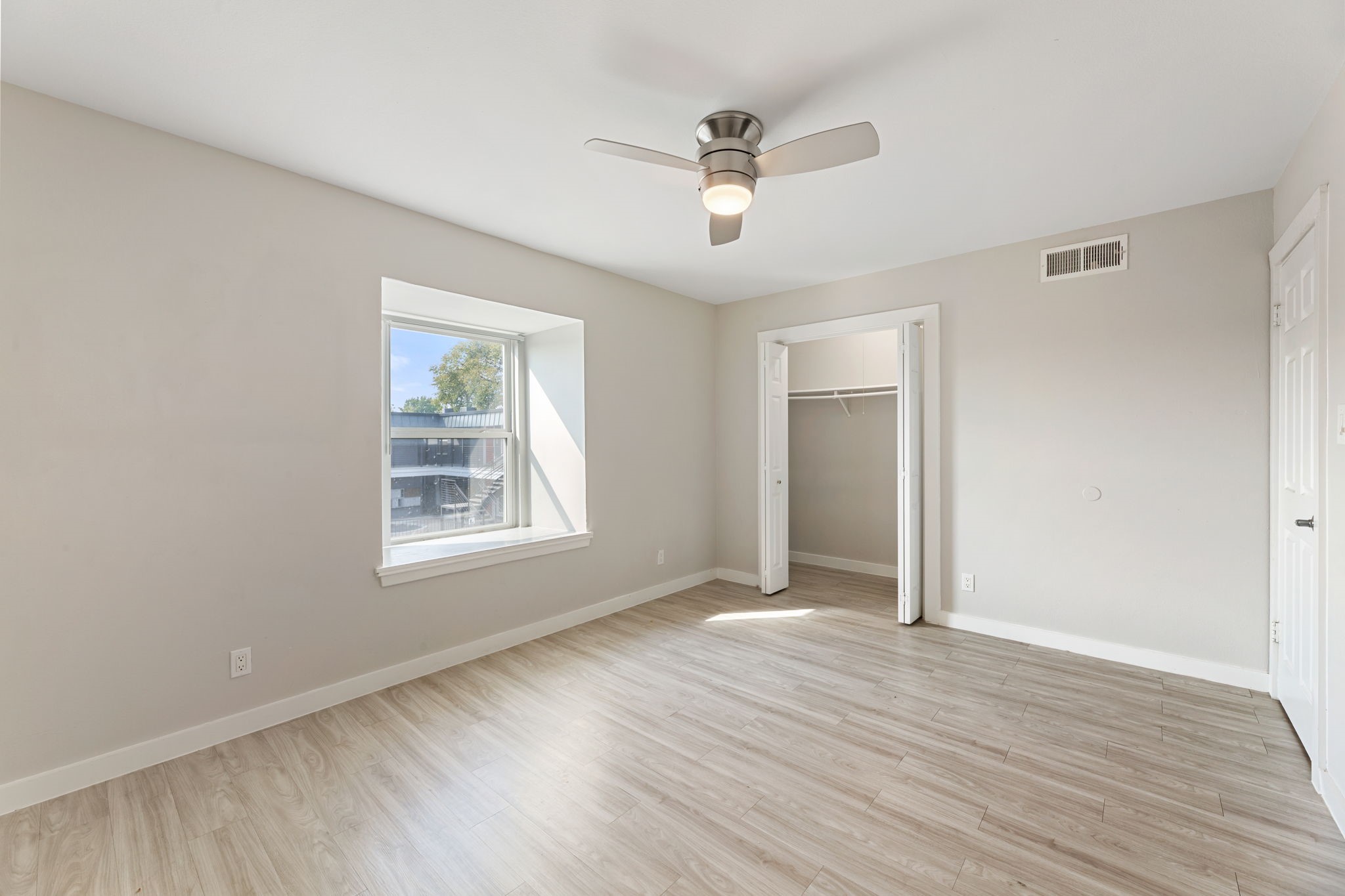 5005 Manor Road, Unit 122 Austin, TX 78723 - Photo 22 of 35 a view of an empty room with wooden floor and a window