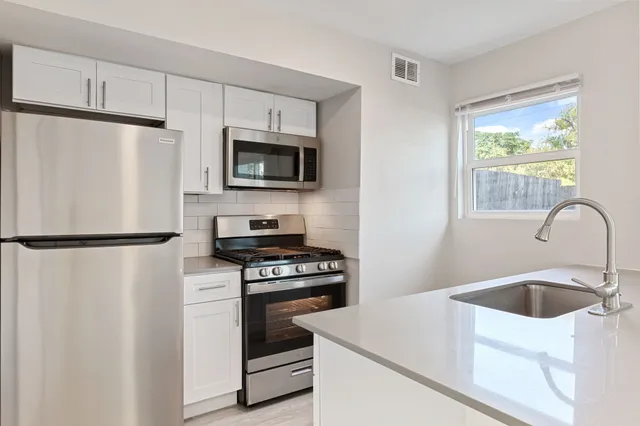 a kitchen with white cabinets and white appliances