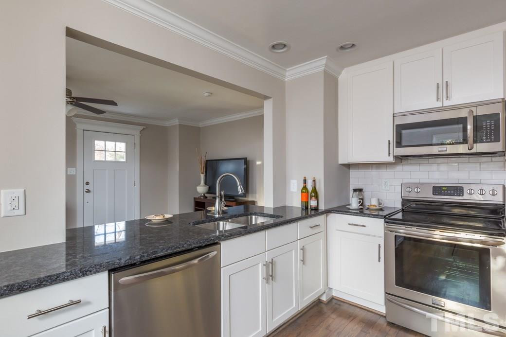 820 Colleton Road Raleigh, NC 27610 - Photo 13 of 25 a kitchen with sink a stove and cabinets