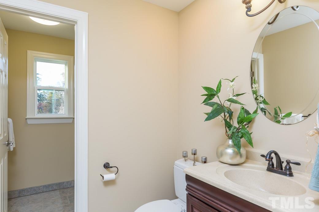 820 Colleton Road Raleigh, NC 27610 - Photo 18 of 25 a bathroom with a sink a toilet and a mirror