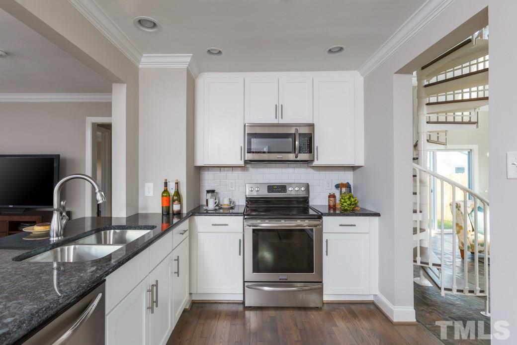 820 Colleton Road Raleigh, NC 27610 - Photo 8 of 25 a kitchen with stainless steel appliances granite countertop a stove a sink dishwasher and a microwave oven with wooden cabinets