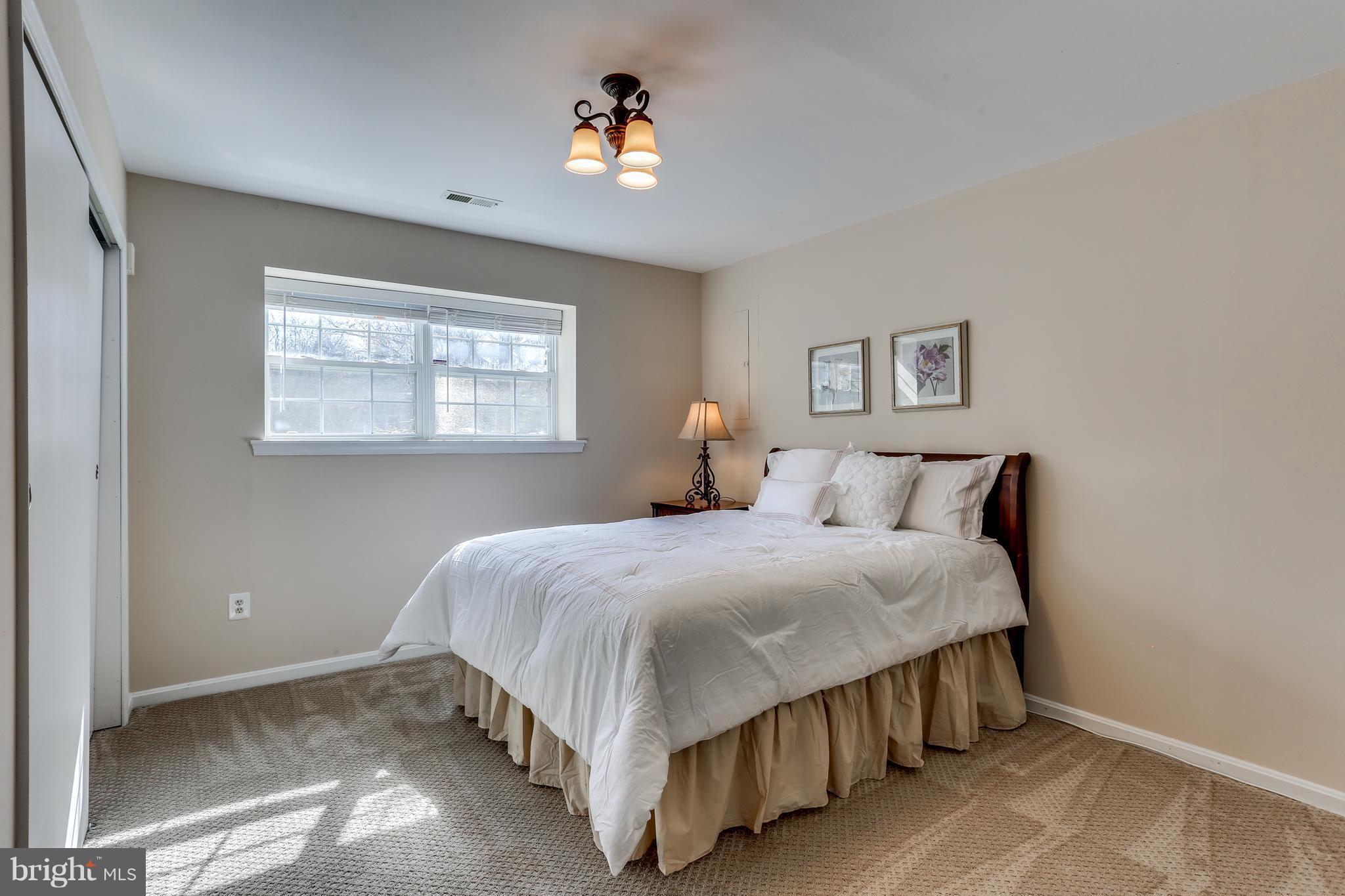 6141 Good Hunters Ride Columbia, MD 21045 - Photo 25 of 28 a bedroom with a bed lamp and a window