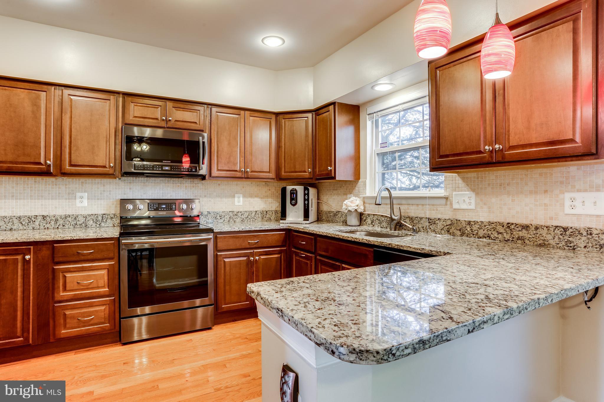 6141 Good Hunters Ride Columbia, MD 21045 - Photo 7 of 28 a kitchen with stainless steel appliances granite countertop a sink stove and microwave