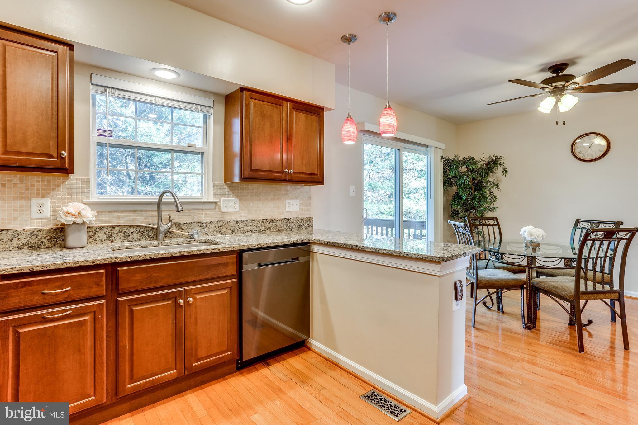 6141 Good Hunters Ride Columbia, MD 21045 - Photo 9 of 28 a kitchen with granite countertop wooden floors cabinets a dining table and chairs