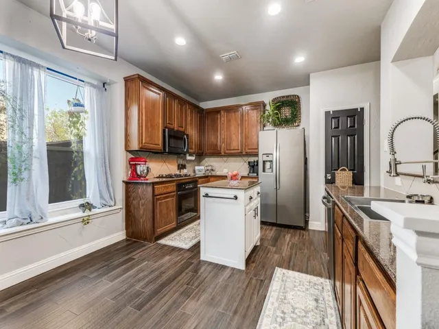 a kitchen with a sink appliances cabinets and a counter top space