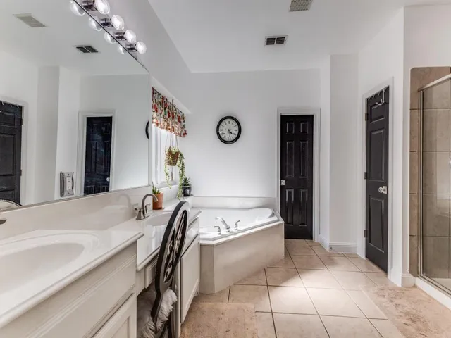 a spacious bathroom with a sink a mirror and a shower