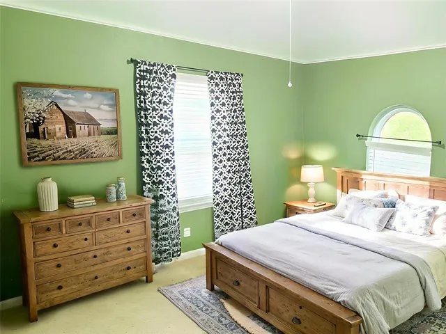 a bedroom with a bed and a painting on the wall