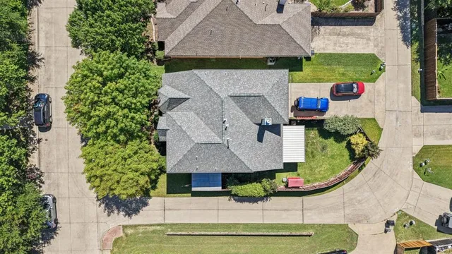 an aerial view of a house with swimming pool and large trees