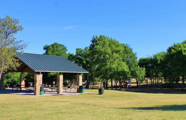 a view of a swimming pool with lawn chairs under an umbrella