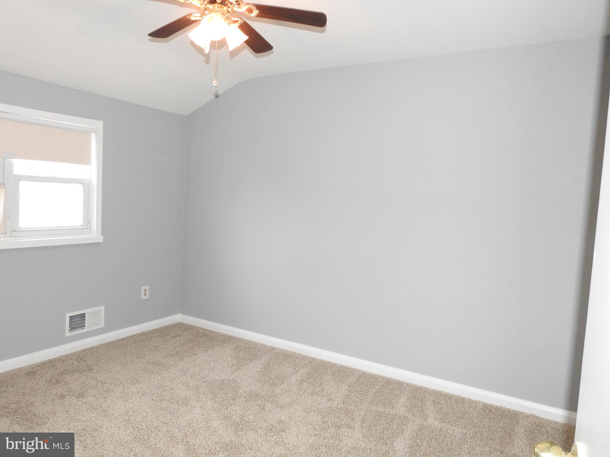 7828 Charlesmont Road Baltimore, MD 21222 - Photo 16 of 22 an empty room with a chandelier fan