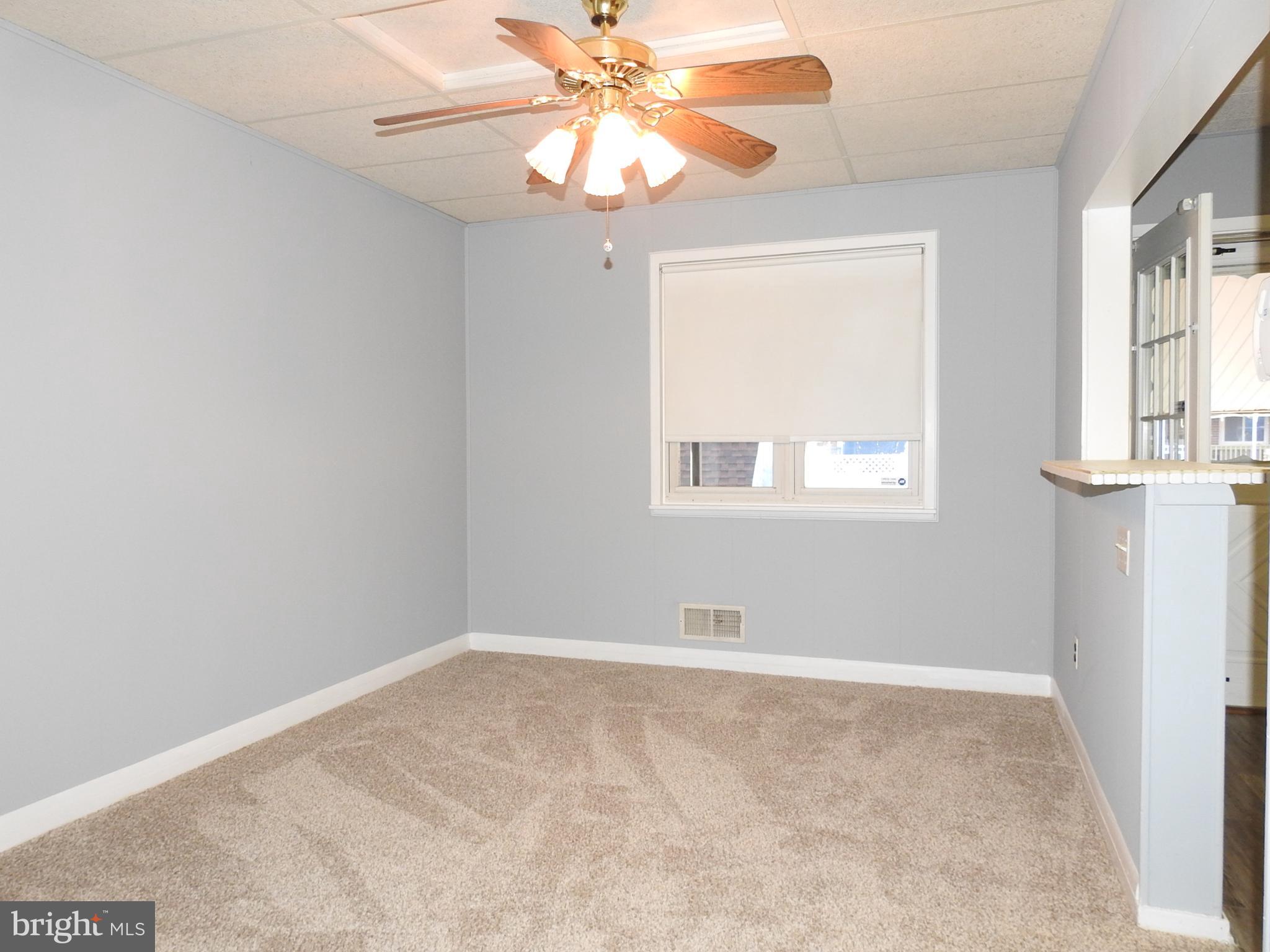 7828 Charlesmont Road Baltimore, MD 21222 - Photo 5 of 22 an empty room with windows and fan