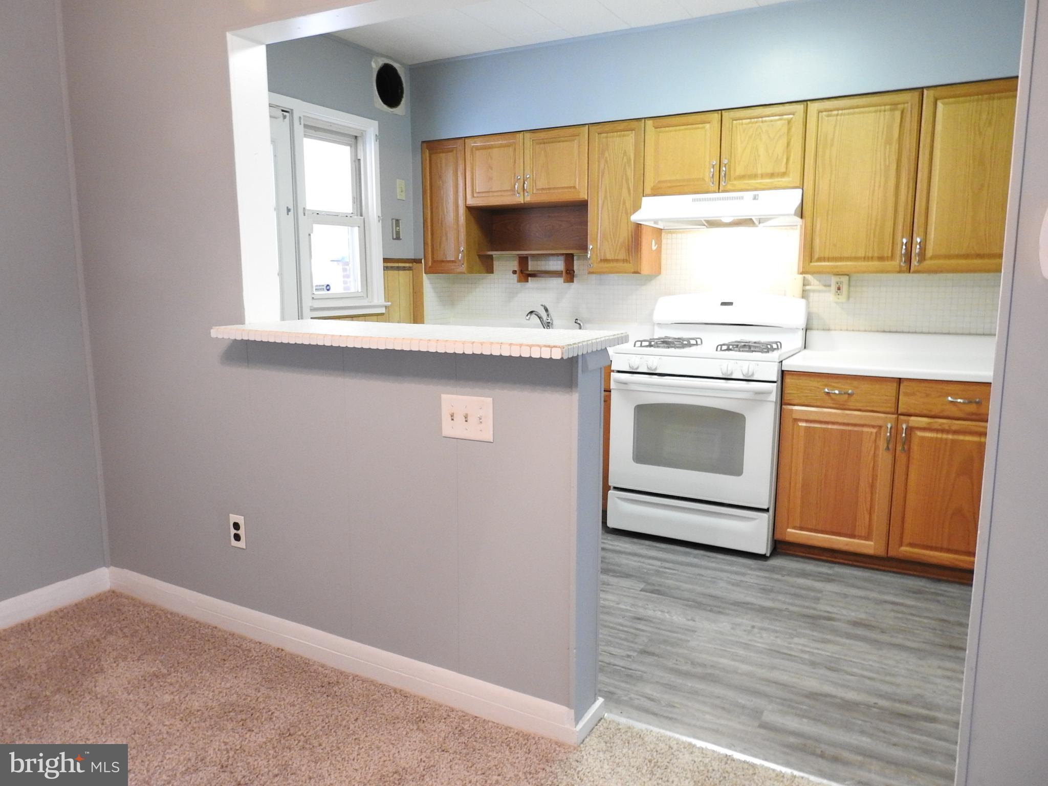 7828 Charlesmont Road Baltimore, MD 21222 - Photo 6 of 22 a kitchen with a stove a sink and a microwave
