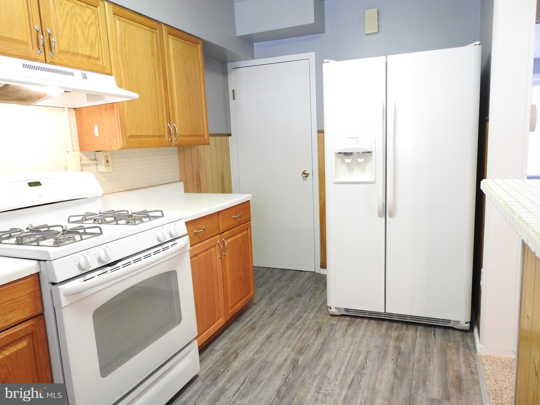 7828 Charlesmont Road Baltimore, MD 21222 - Photo 7 of 22 a kitchen with a stove a sink and a refrigerator