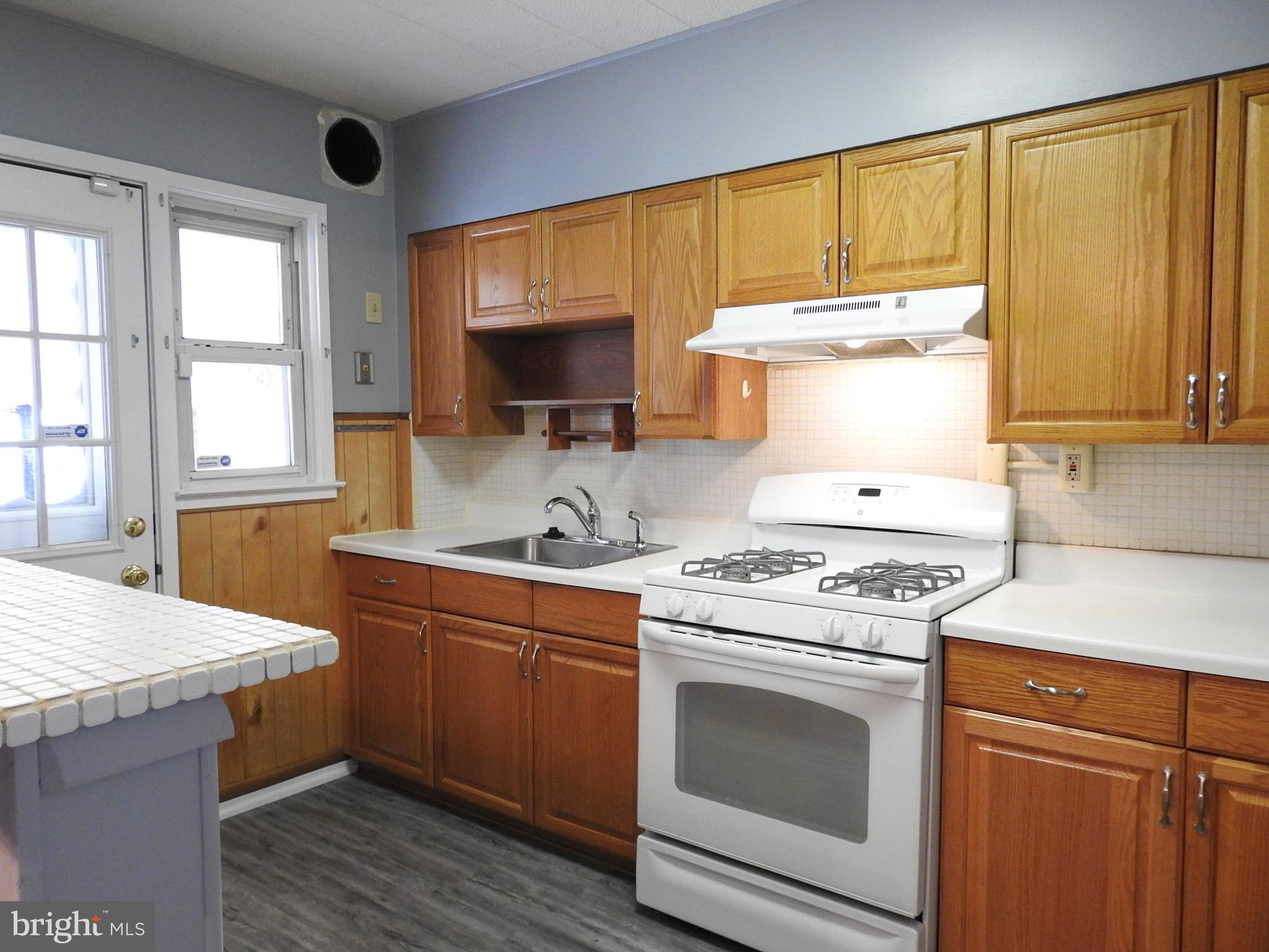 7828 Charlesmont Road Baltimore, MD 21222 - Photo 8 of 22 a kitchen with a stove a sink and a microwave