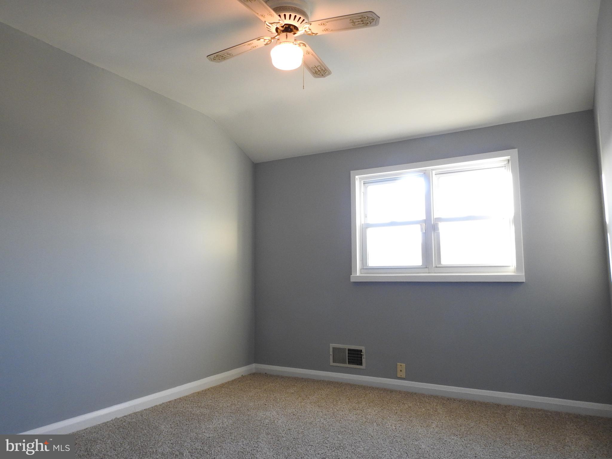7828 Charlesmont Road Baltimore, MD 21222 - Photo 9 of 22 an empty room with windows and fan