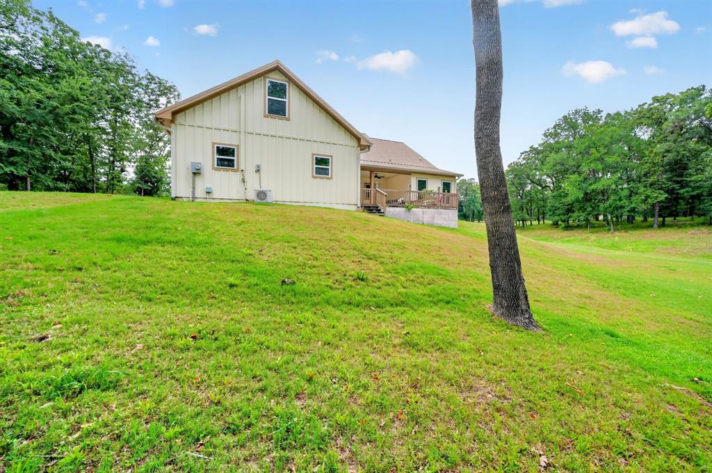 5230 Esquire Estates Road Mabank, TX 75156 - Photo 30 of 39 Expansive sloped lawn surrounding a board and batten siding residence with a covered porch
