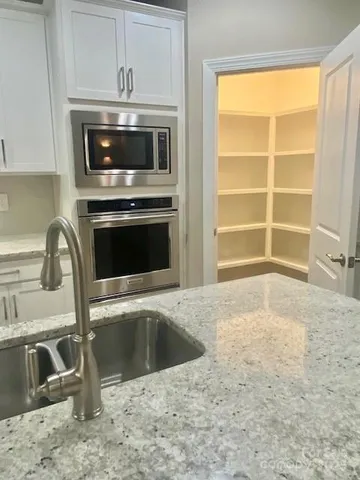 a kitchen with granite countertop a sink and a stove top oven