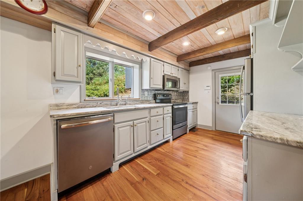 284 Eaton Run Road Jefferson, PA 15344 - Photo 29 of 41 a kitchen with stainless steel appliances granite countertop a stove a sink dishwasher a microwave oven with cabinets and wooden floor