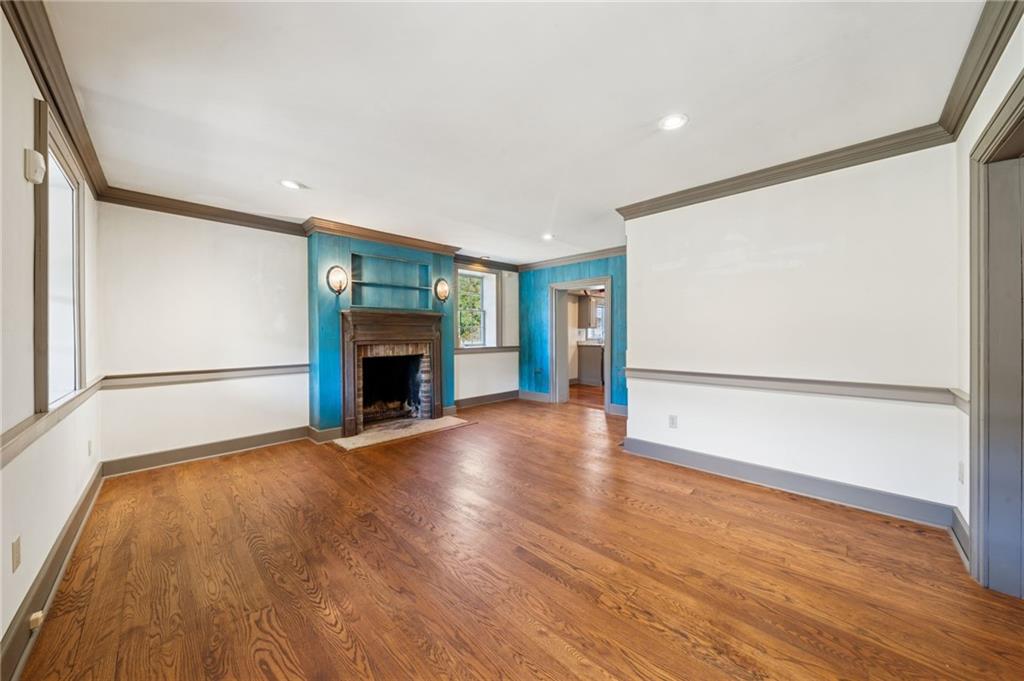 284 Eaton Run Road Jefferson, PA 15344 - Photo 7 of 41 an empty room with wooden floor fireplace and windows