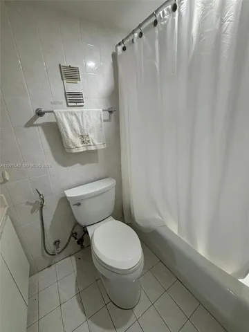 a white toilet sitting next to a shower curtain