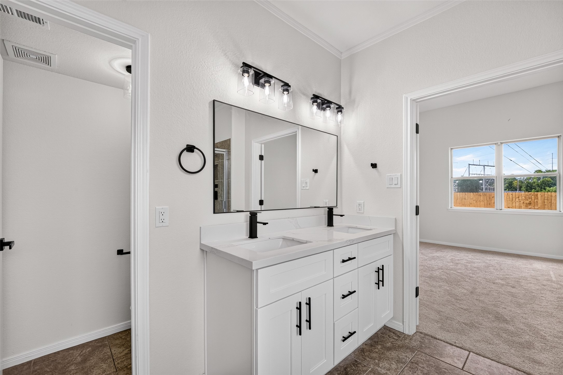 22623 Ebbets Field Drive Spring, TX 77389 - Photo 23 of 43 Start your morning in a bright, spa-like bathroom filled with beautiful natural light. The sleek dual-sink vanity offers plenty of elbow room for two, accented by bold black hardware and clean modern finishes that make your daily routine feel like a treat.