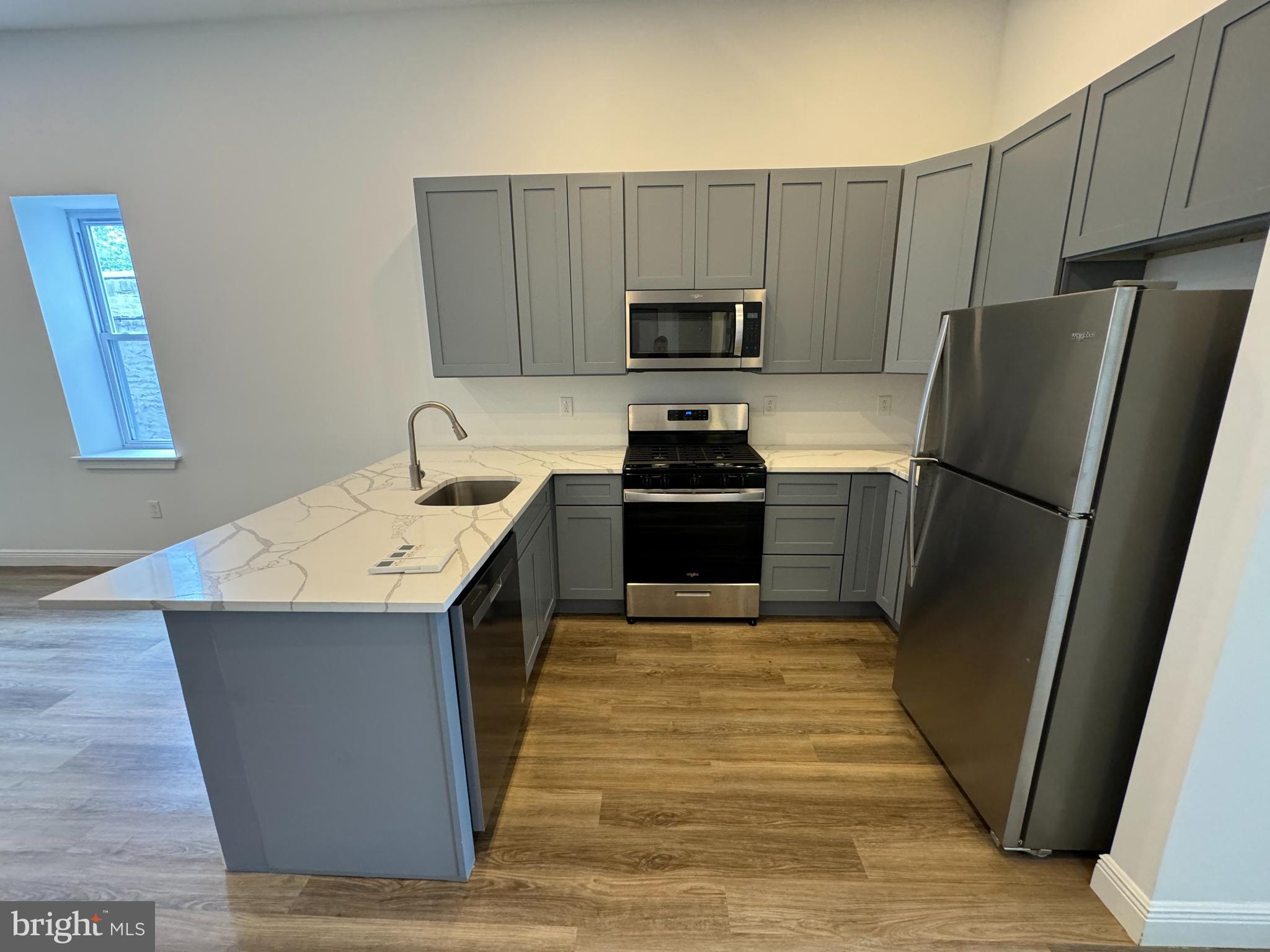 a kitchen with stainless steel appliances a refrigerator stove microwave and sink