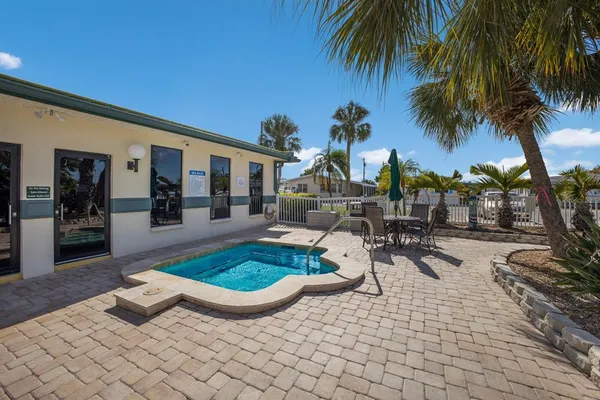 a view of a backyard with swimming pool and sitting area