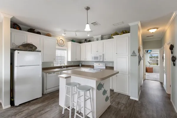 a kitchen with kitchen island a refrigerator a stove a sink and a island