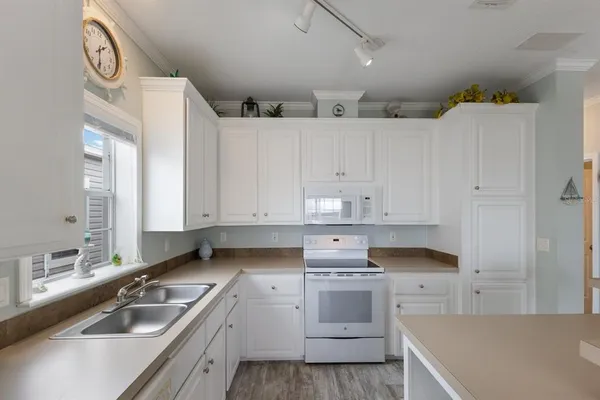 a kitchen with granite countertop a sink a stove and cabinets