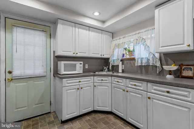 a kitchen with white cabinets and white appliances