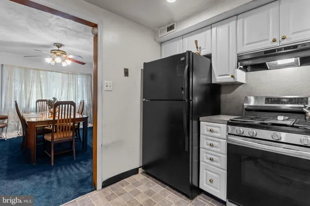 a kitchen with a refrigerator and a stove top oven