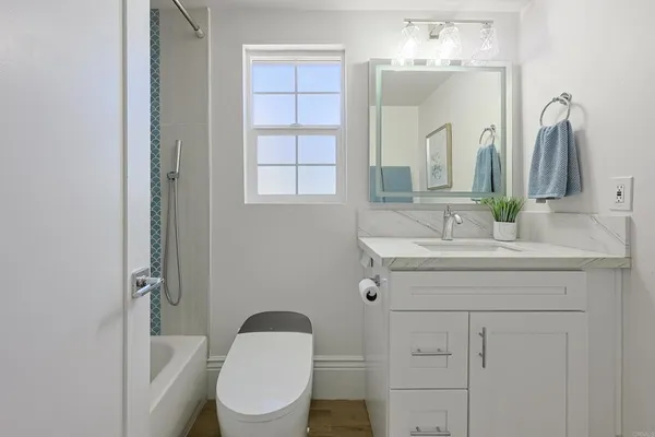 a bathroom with a sink a toilet and mirror
