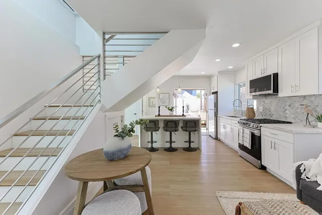 a kitchen with a table chairs sink and cabinets