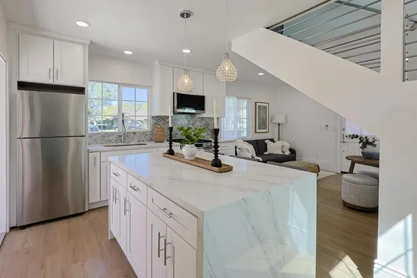 a kitchen with stainless steel appliances kitchen island a refrigerator sink and cabinets