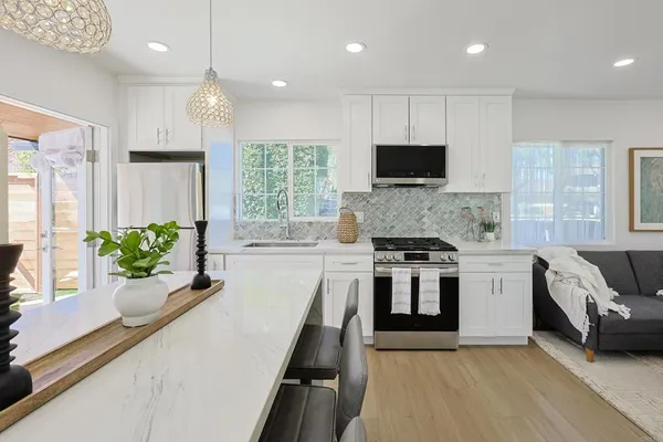 a kitchen with a stove a sink and a microwave