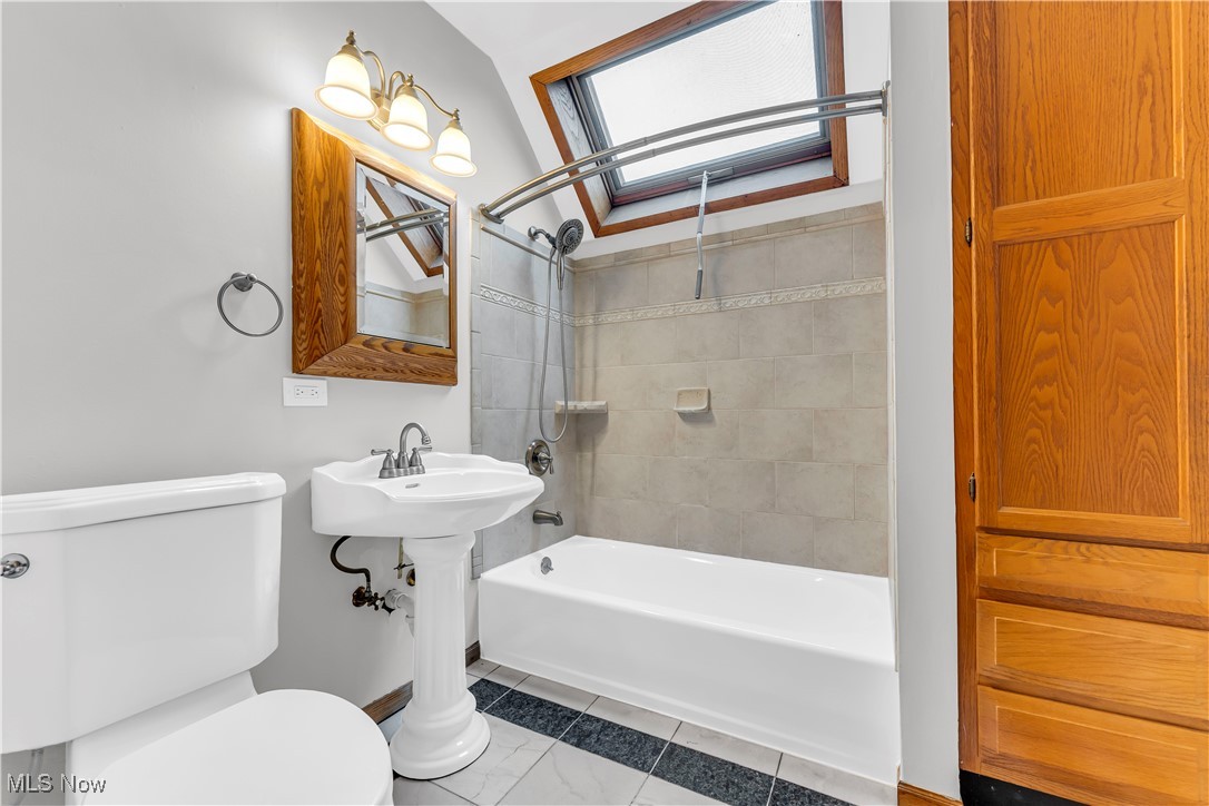 3374 Fulton Road Cleveland, OH 44109 - Photo 17 of 27 Full bath featuring bathing tub / shower combination, a skylight, and tile patterned flooring