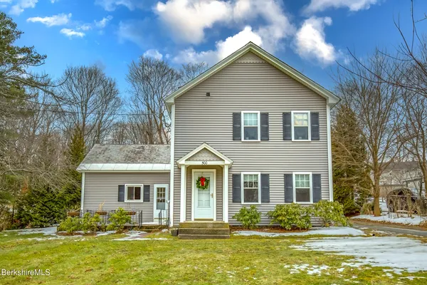 a front view of house with yard and trees around