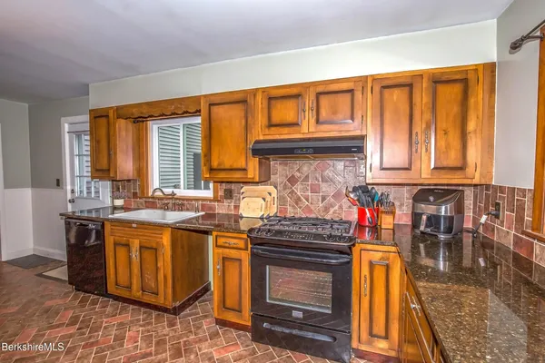 a kitchen with stainless steel appliances granite countertop a stove a sink and dishwasher
